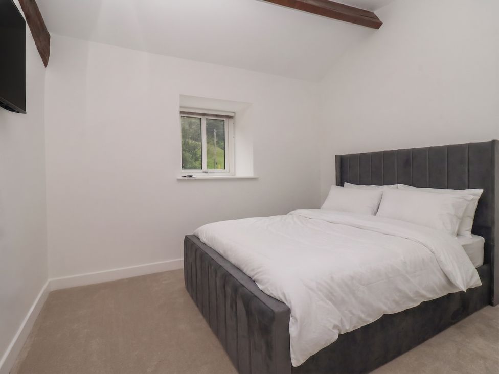 A bedroom with a bed and television at Virginia Cottage in Skipton