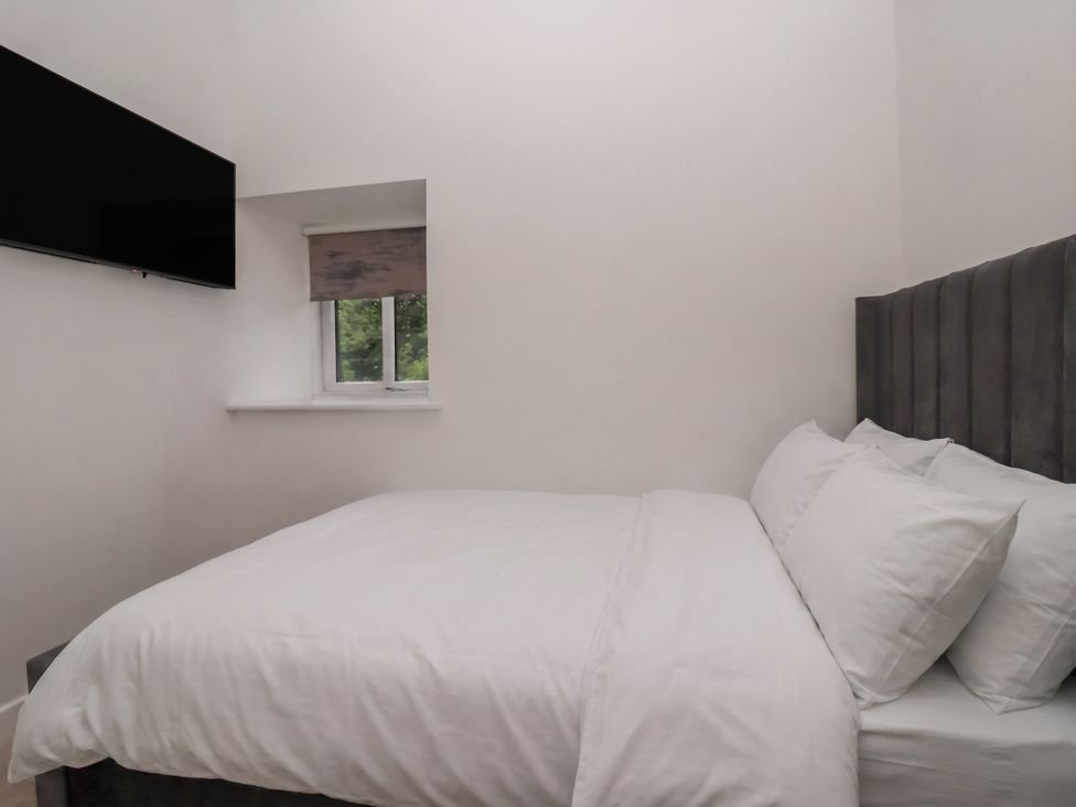 A bedroom with a bed and television at Virginia Cottage in Skipton