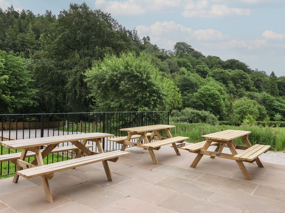 An outdoor seating area with picnic tables at Virginia Cottage in Skipton
