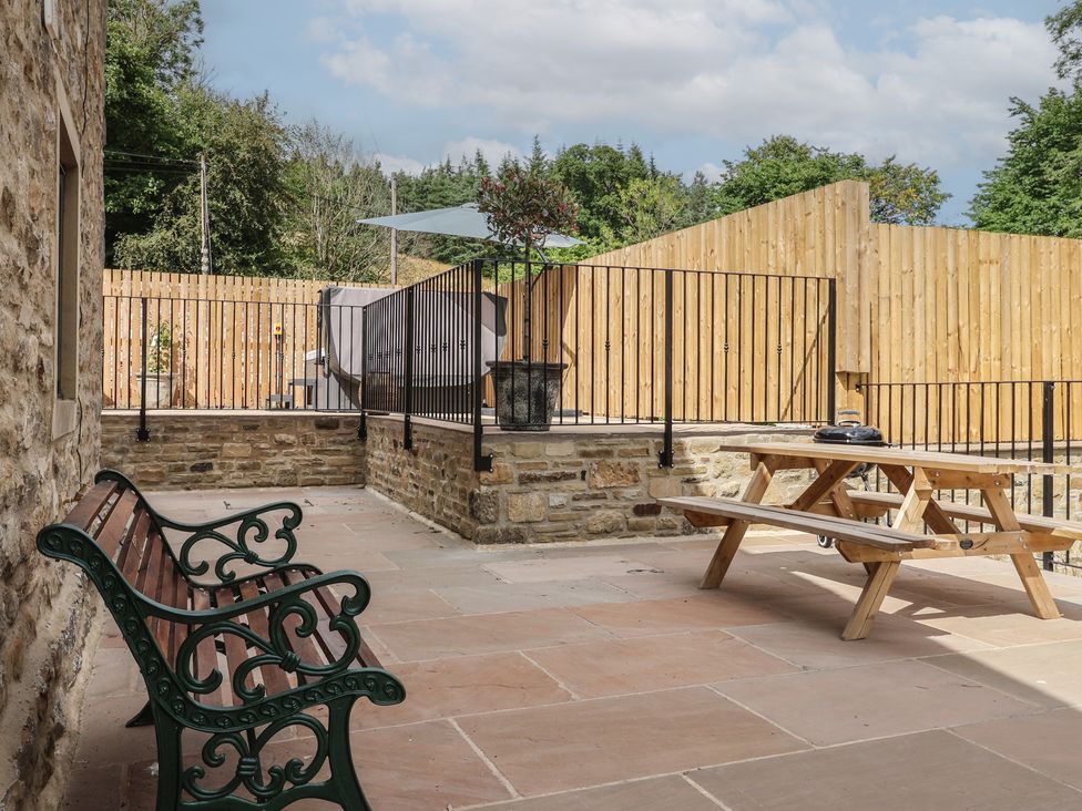 An outdoor area with a picnic table and bench at Virginia Cottage in Winterburn
