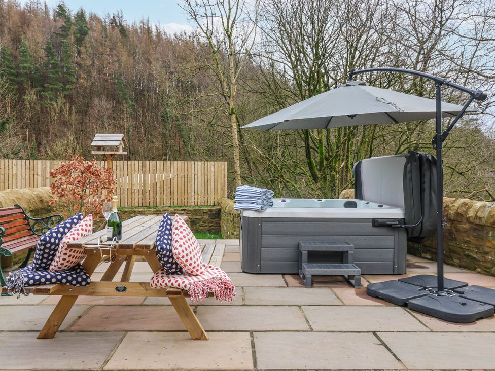 An outdoor area with a hot tub and picnic table at Beckside in Skipton
