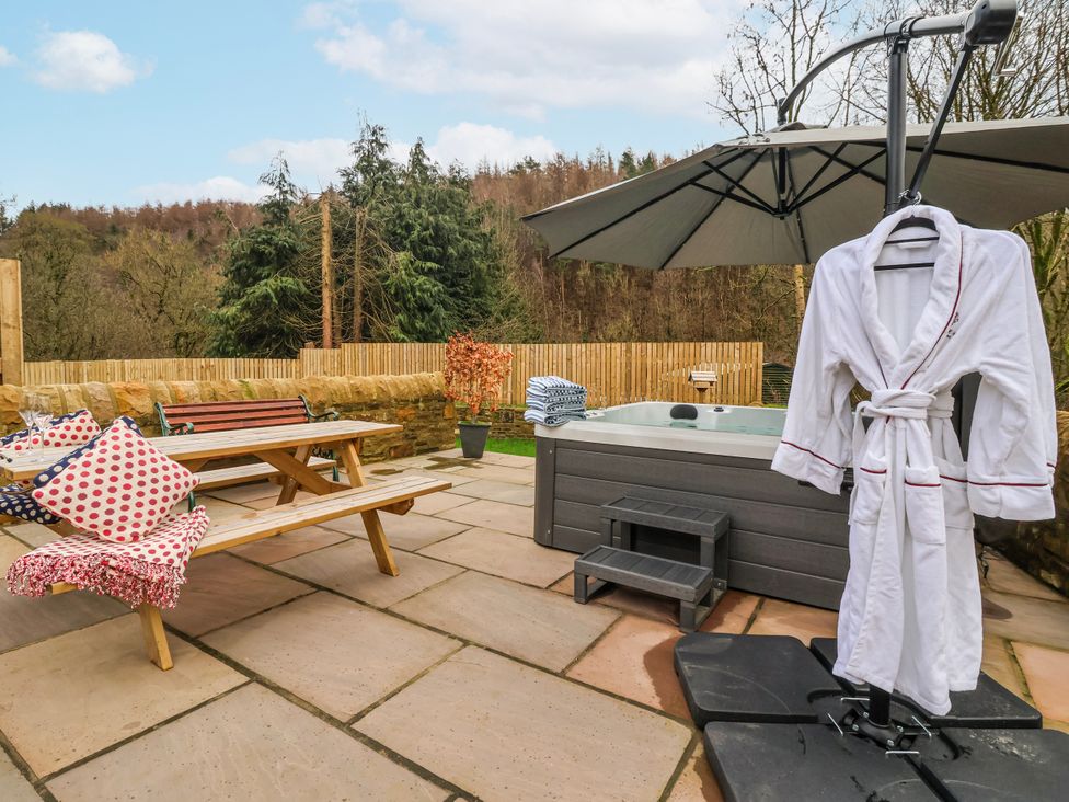 An outdoor seating area with a hot tub and a dining table at Beckside in Skipton