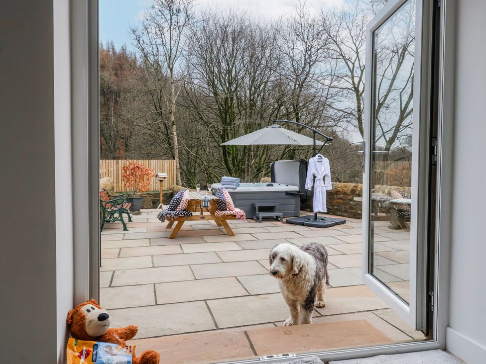 An outdoor area with a dog and a hot tub at Beckside, Skipton