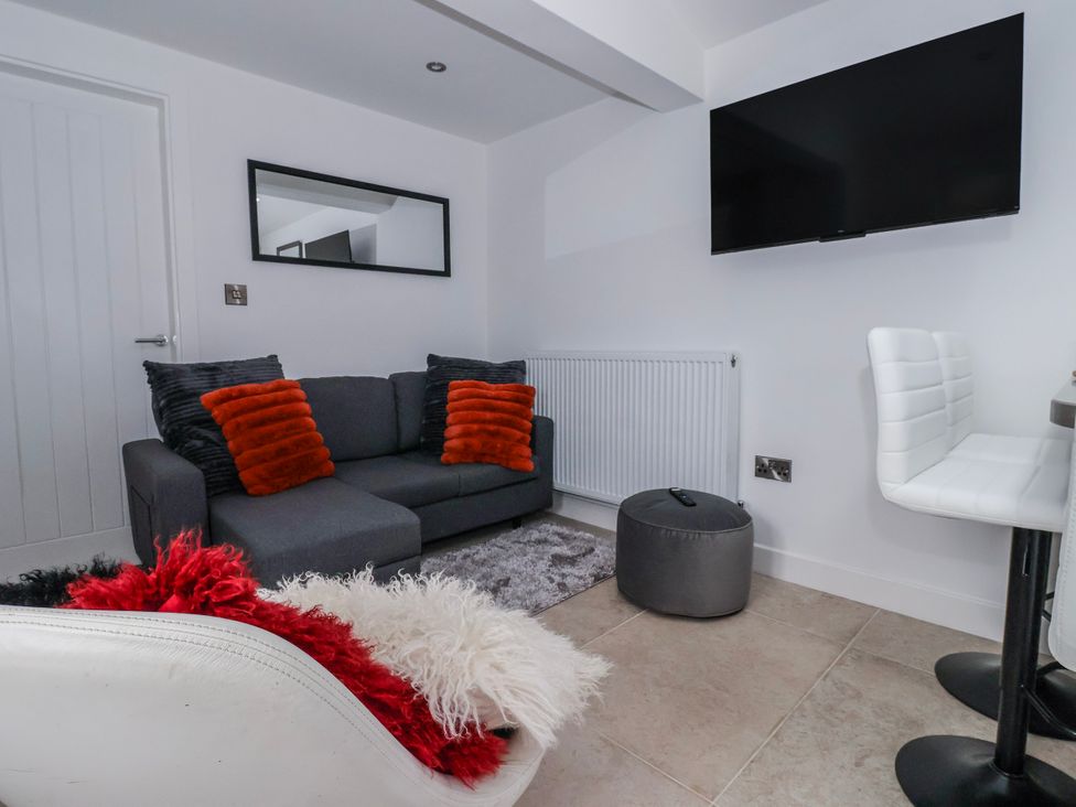 A snug with a sofa and a television at Beckside in Skipton