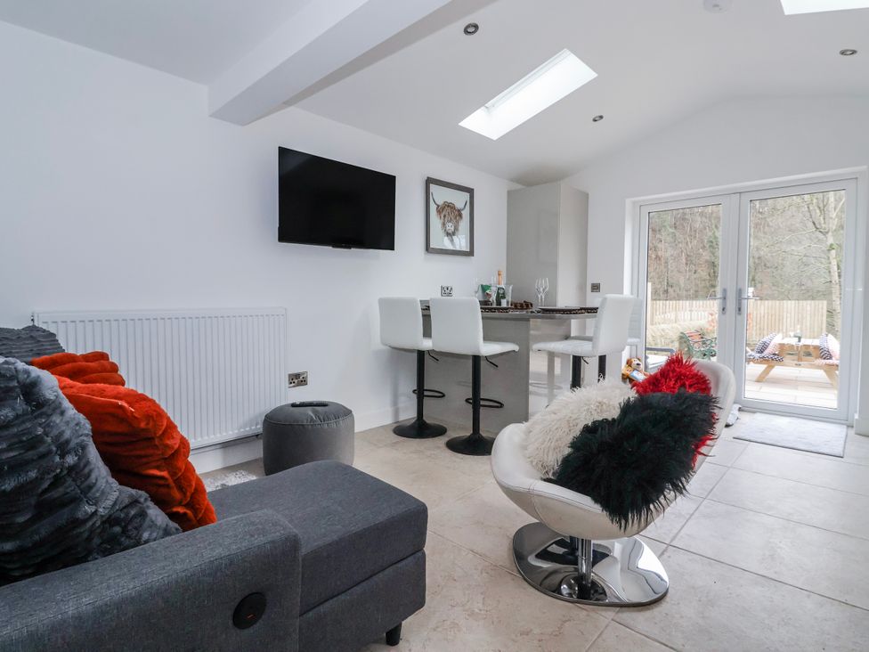 A living room with a television and patio doors at Beckside in Skipton