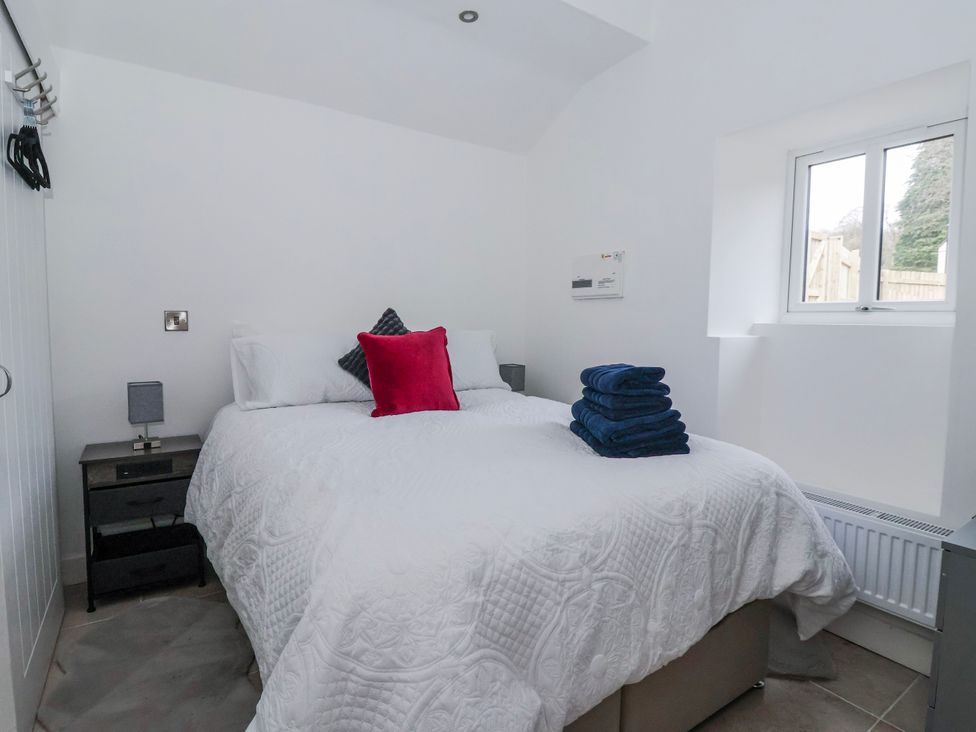 A bedroom with a bed and nightstand at Beckside in Skipton