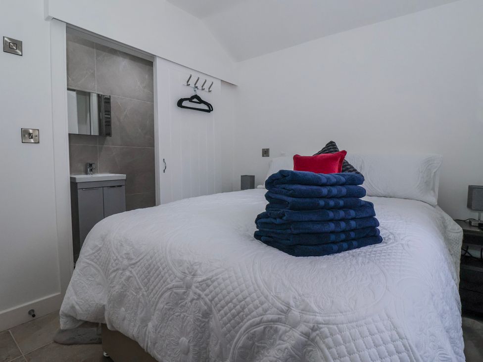A bedroom with a bed and towels stacked on top at Beckside in Skipton