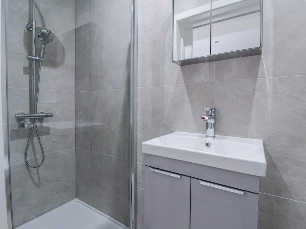 A bathroom with a shower and sink at Beckside in Skipton