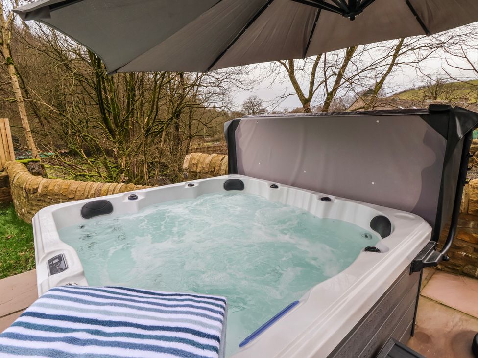A hot tub and towel under an umbrella at Beckside in Skipton