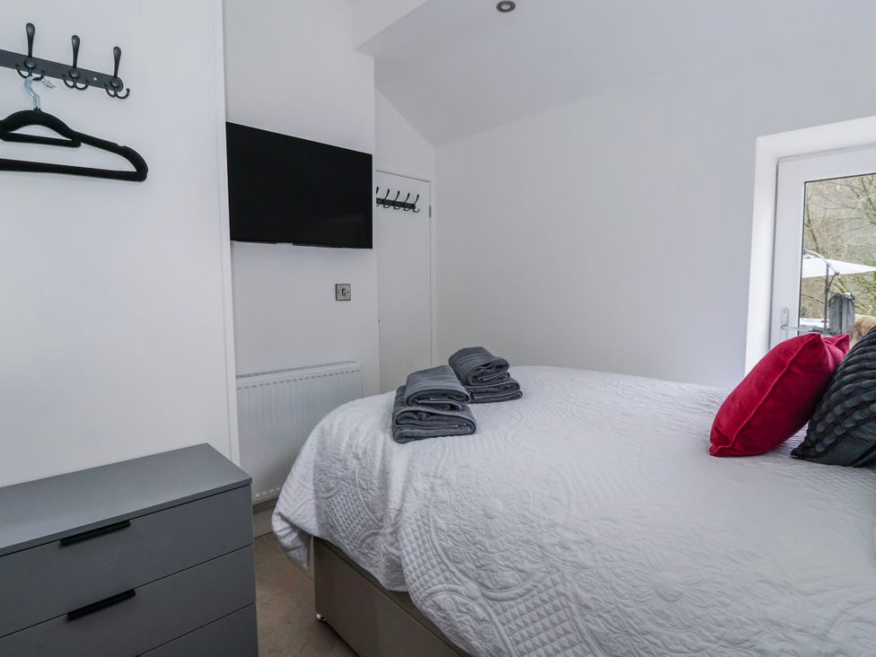 A bedroom with a bed and television at John's Lodge in Gargrave