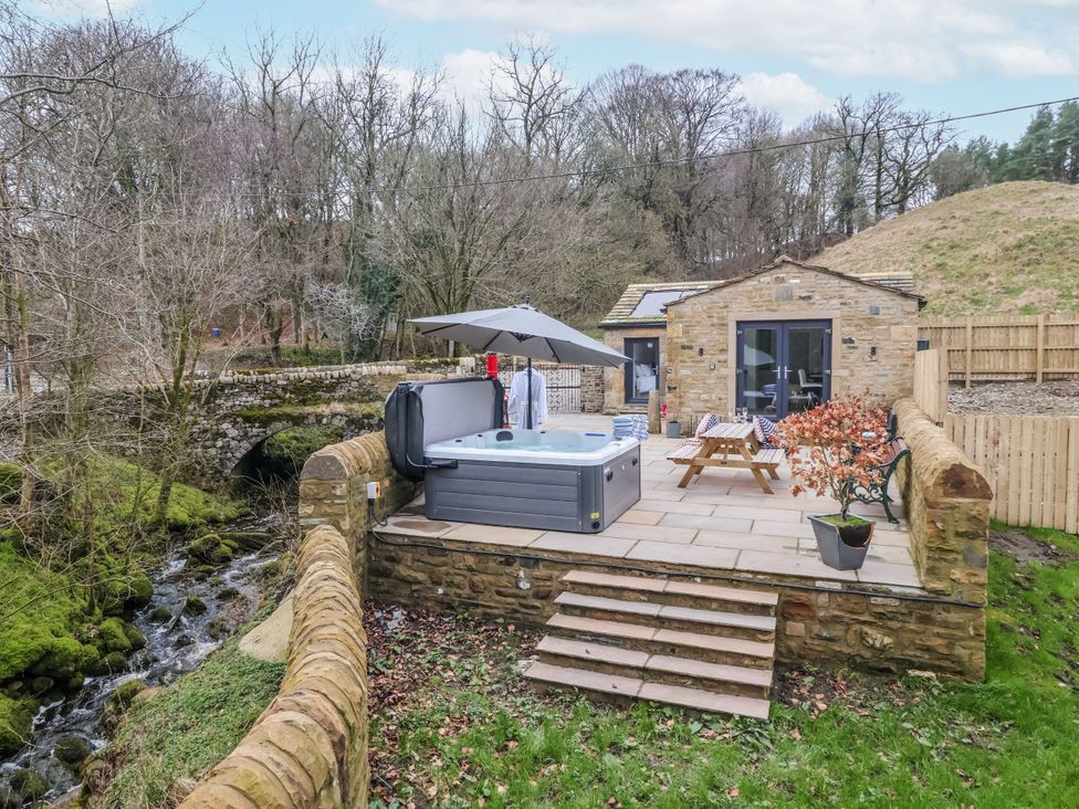 An outdoor area with a hot tub and seating at John's Lodge in Gargrave