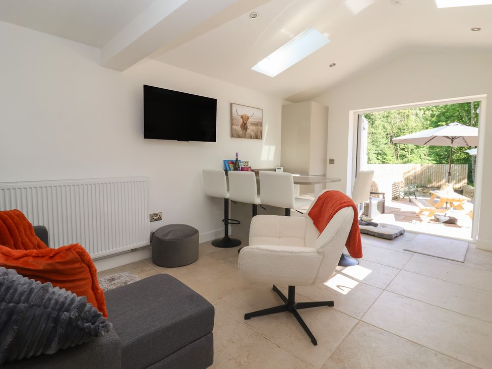 A snug with a television and seating area at John's Lodge in Winterburn