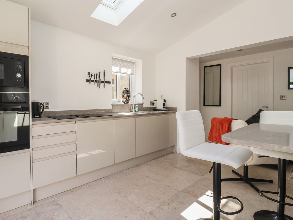 A kitchen with cabinets and table at John's Lodge in Winterburn