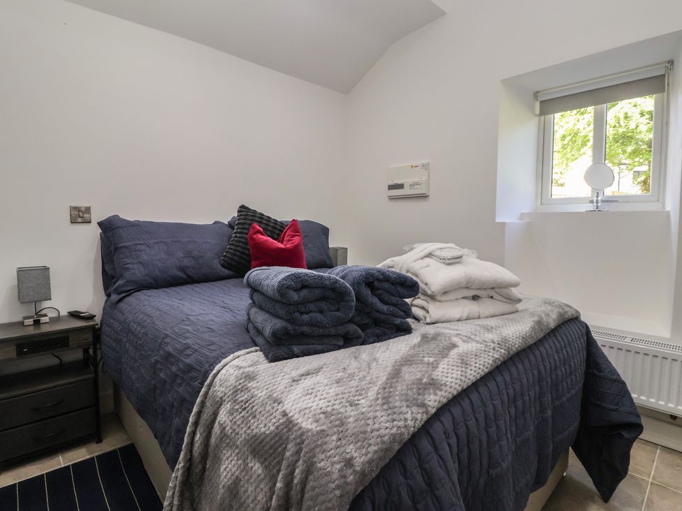 A bedroom with a bed and towels stacked at John's Lodge in Winterburn