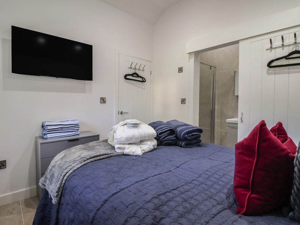 A bedroom with a bed and towels on a dresser at John's Lodge in Winterburn