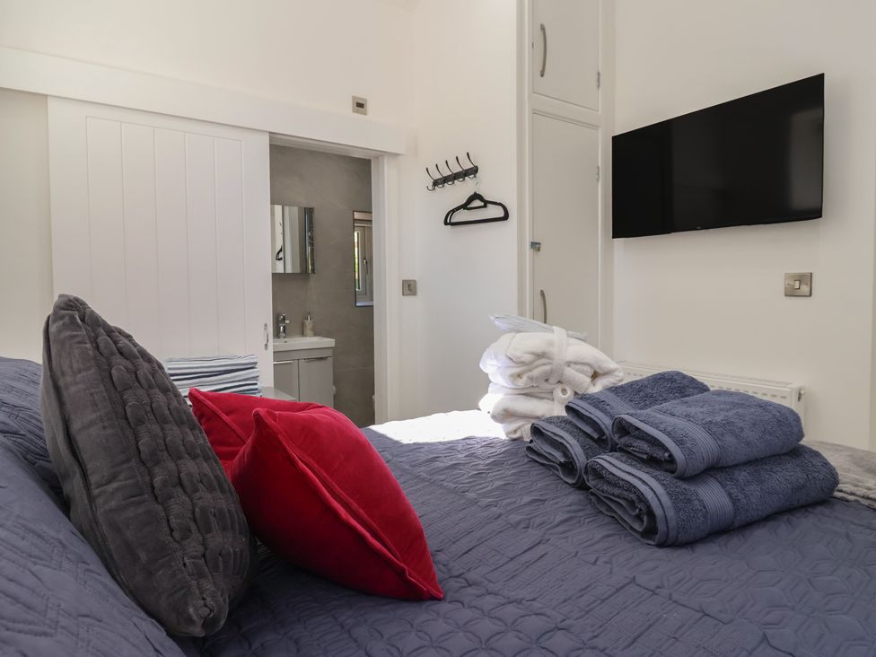 A bedroom with towels and a television at John's Lodge in Winterburn