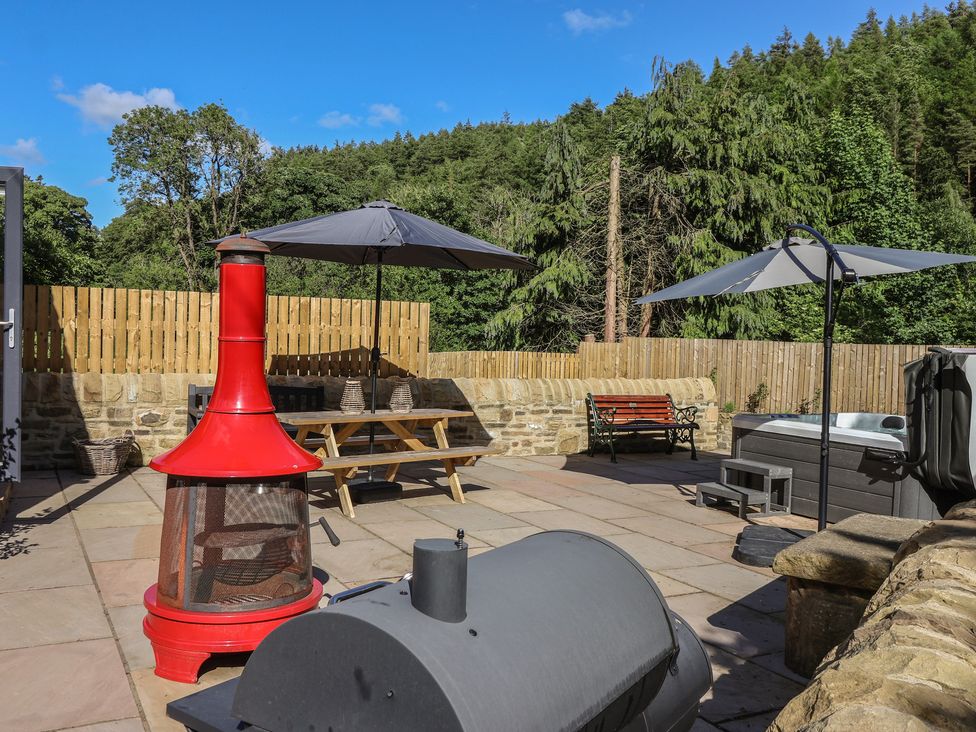 An outdoor patio with a chiminea and picnic table at John's Lodge in Winterburn