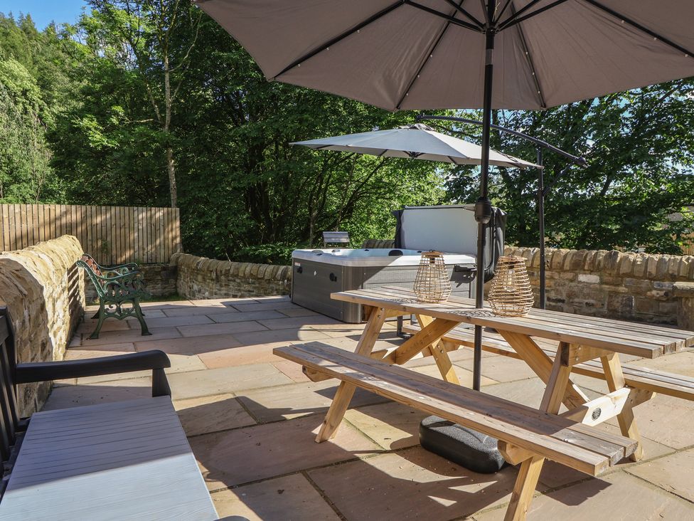 An outdoor area with a hot tub and seating at John's Lodge in Winterburn