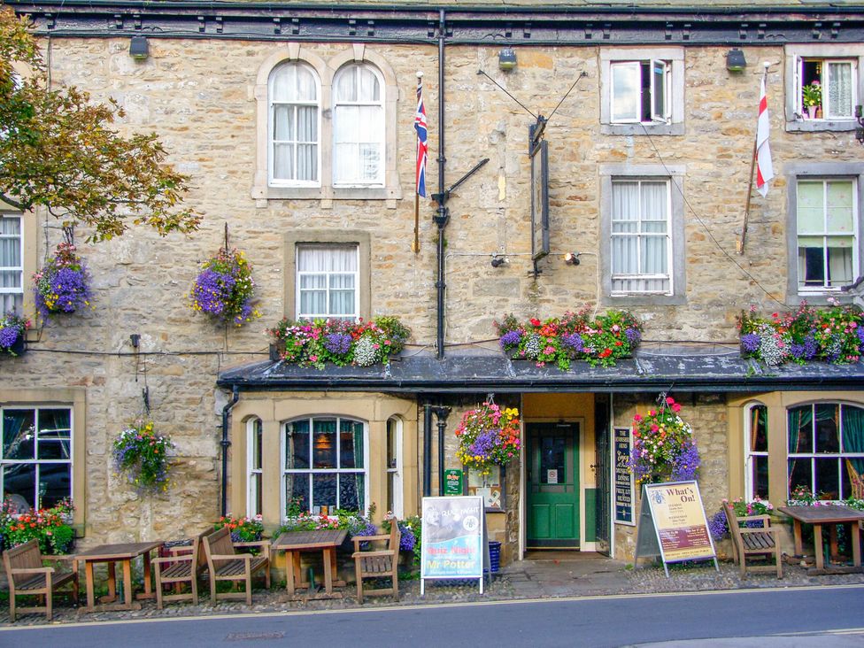 A building with flowers and tables outside at John's Lodge in Winterburn