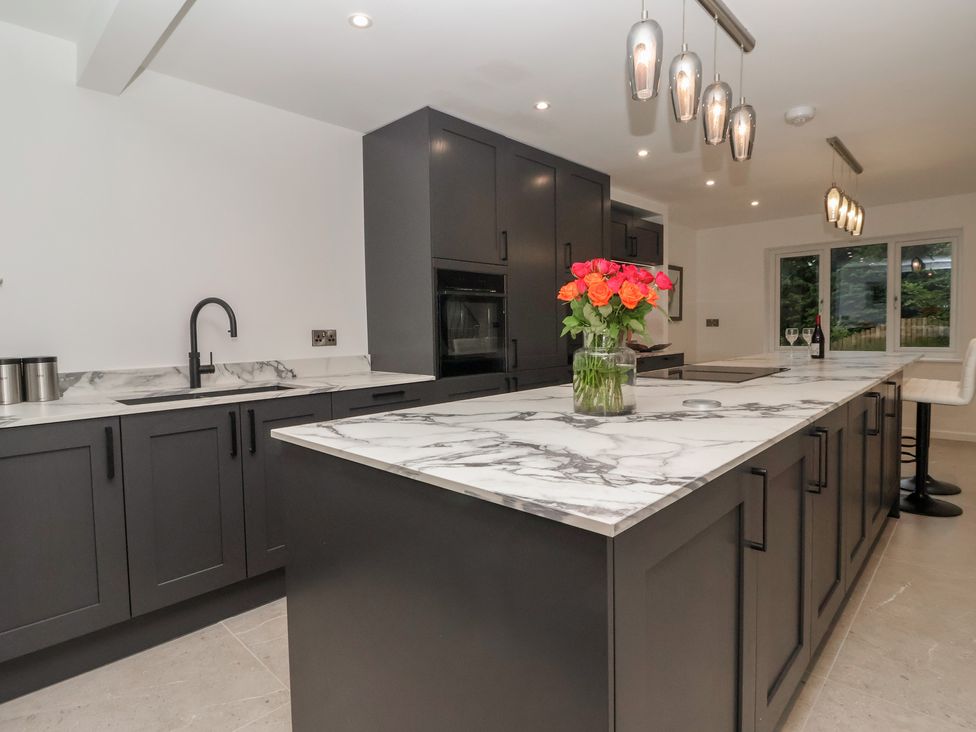 A kitchen with a marble countertop and island at Wood Cottage in Skipton