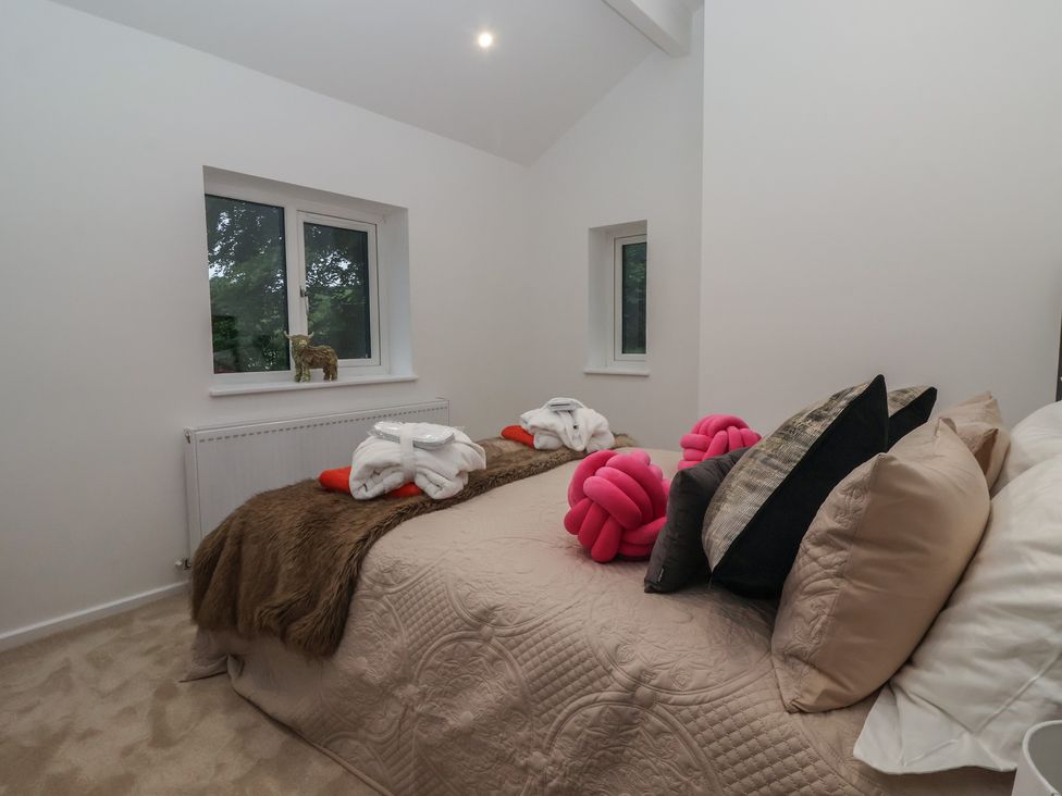 A bedroom with a bed and decorative pillows at Wood Cottage in Skipton