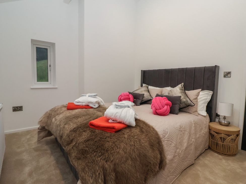 A bedroom with a bed and towels arranged at Wood Cottage in Skipton