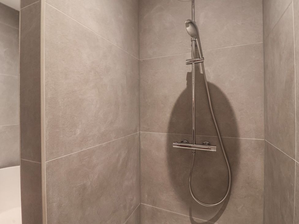 A shower area with wall tiles at Wood Cottage in Skipton