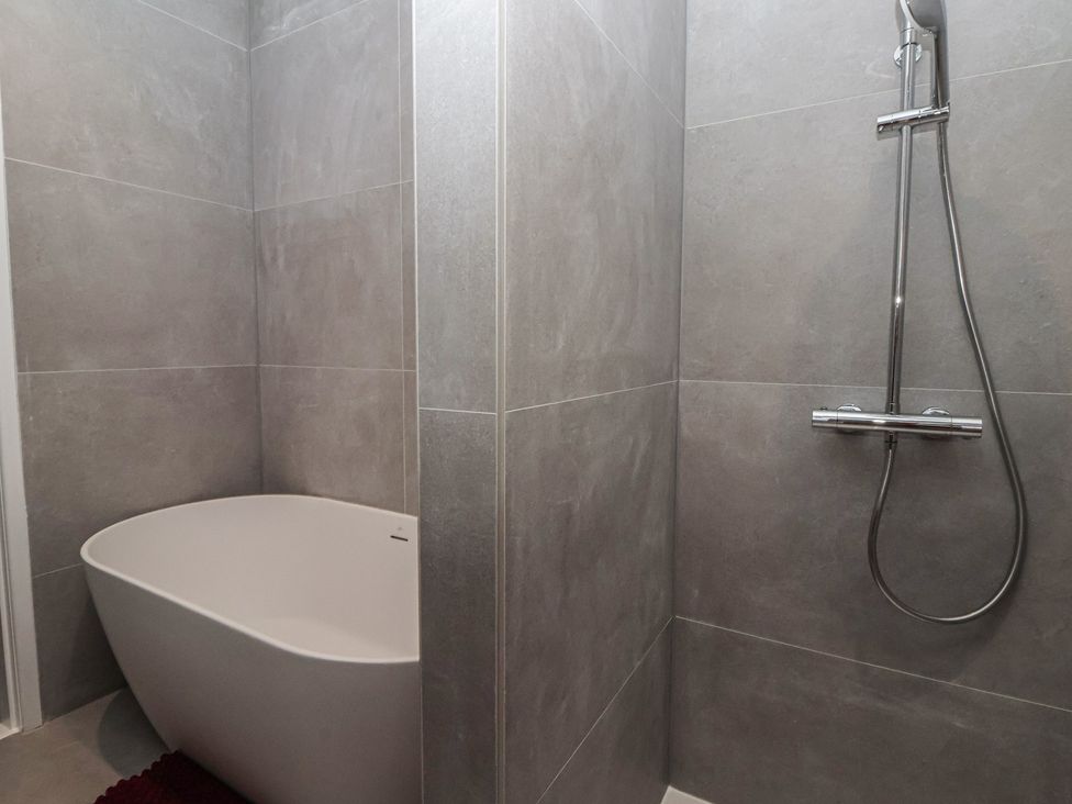A bathroom with a bathtub and shower at Wood Cottage in Skipton