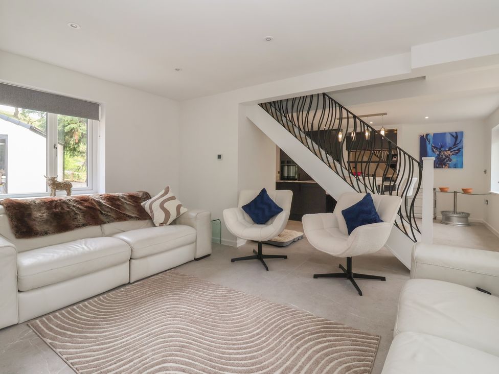 A living room with sofa and chairs at Wood Cottage Winterburn