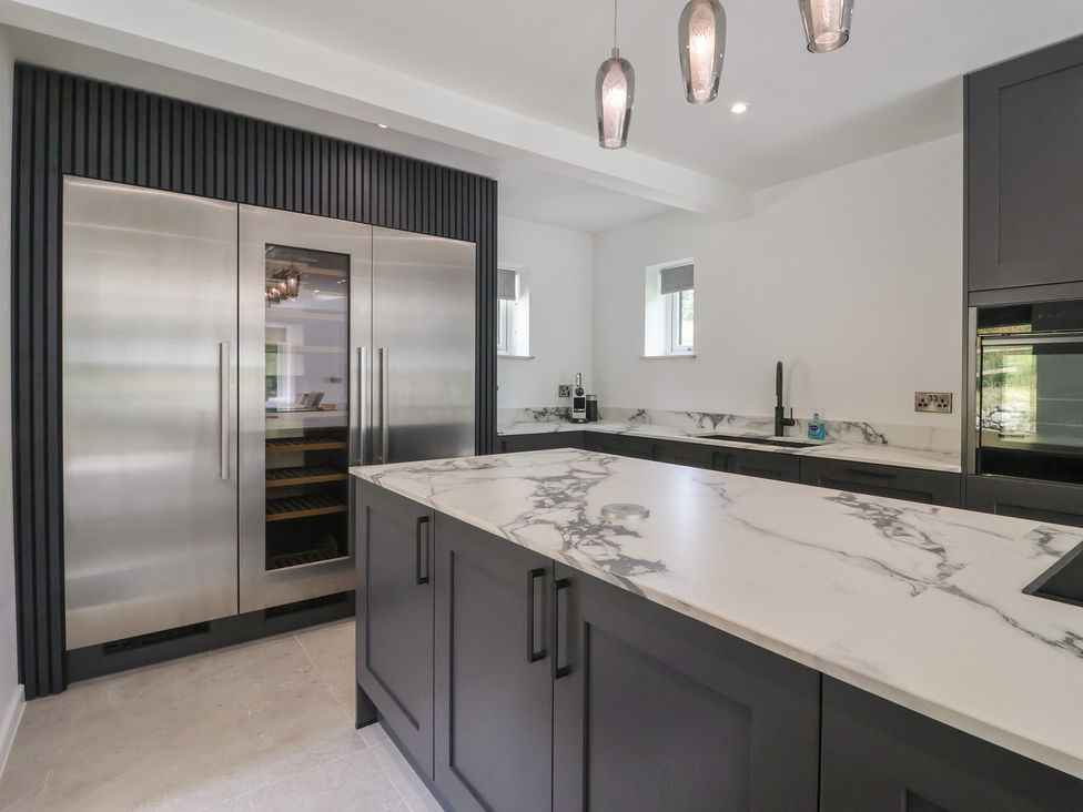 A kitchen with a refrigerator and kitchen island at Wood Cottage in Winterburn