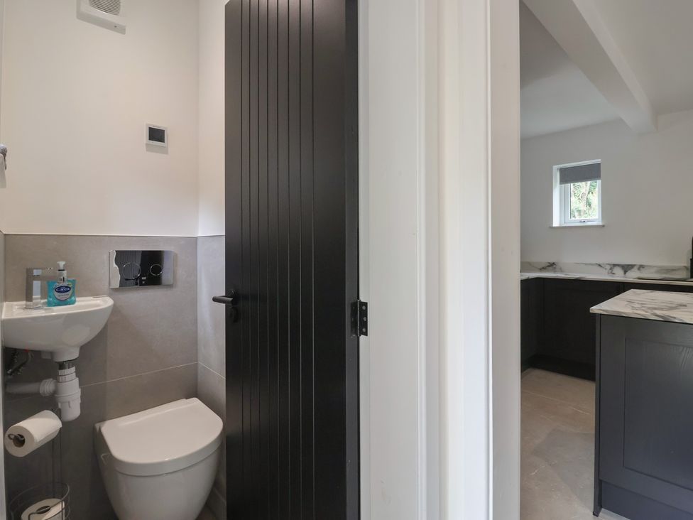 A bathroom with a toilet and sink at Wood Cottage Winterburn