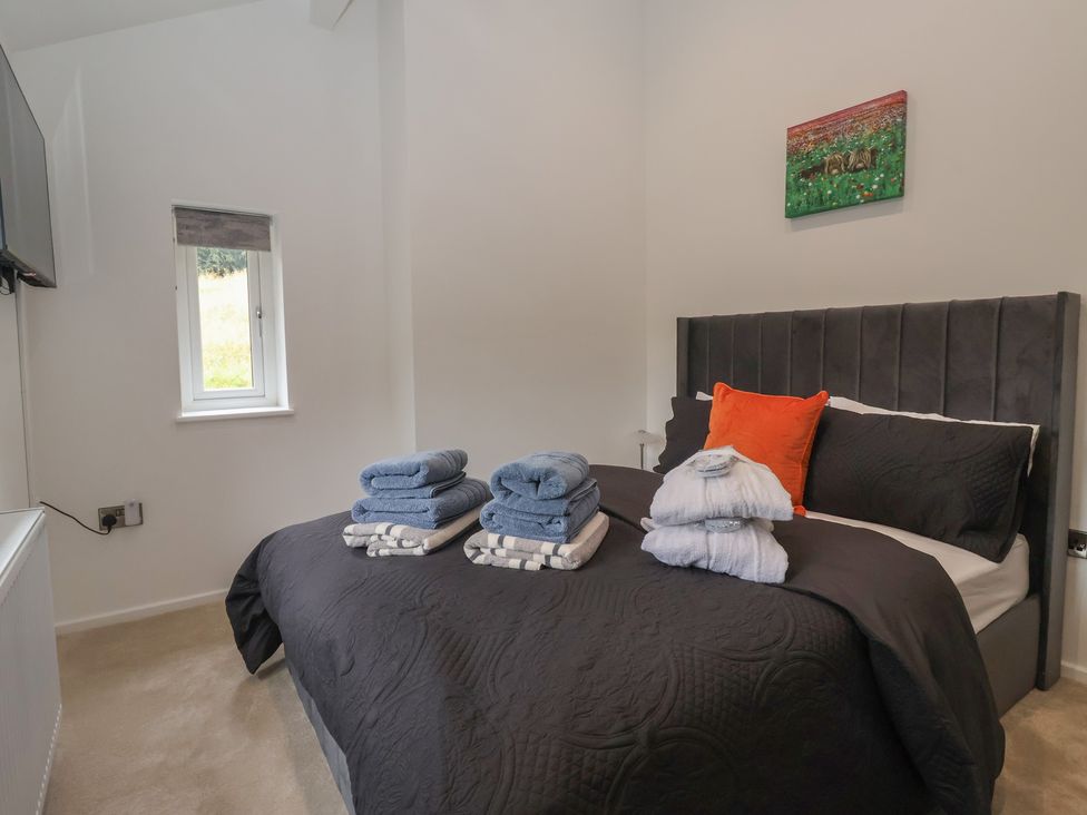 A bedroom with a bed and towels arranged at Wood Cottage in Winterburn