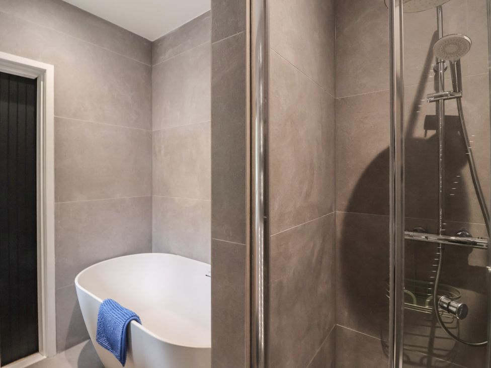 A bathroom with a bathtub and a shower at Wood Cottage Winterburn