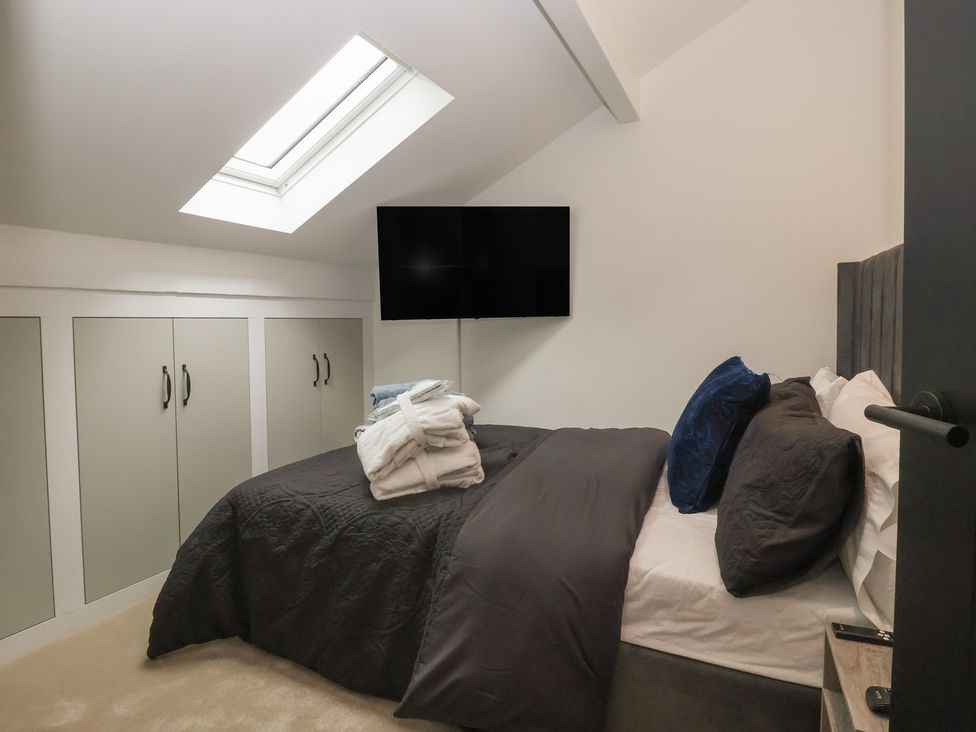 A bedroom with a bed and a television at Wood Cottage in Winterburn