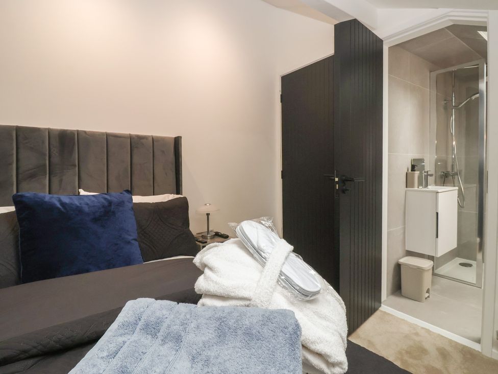 A bedroom with a bed and an attached bathroom at Wood Cottage in Winterburn