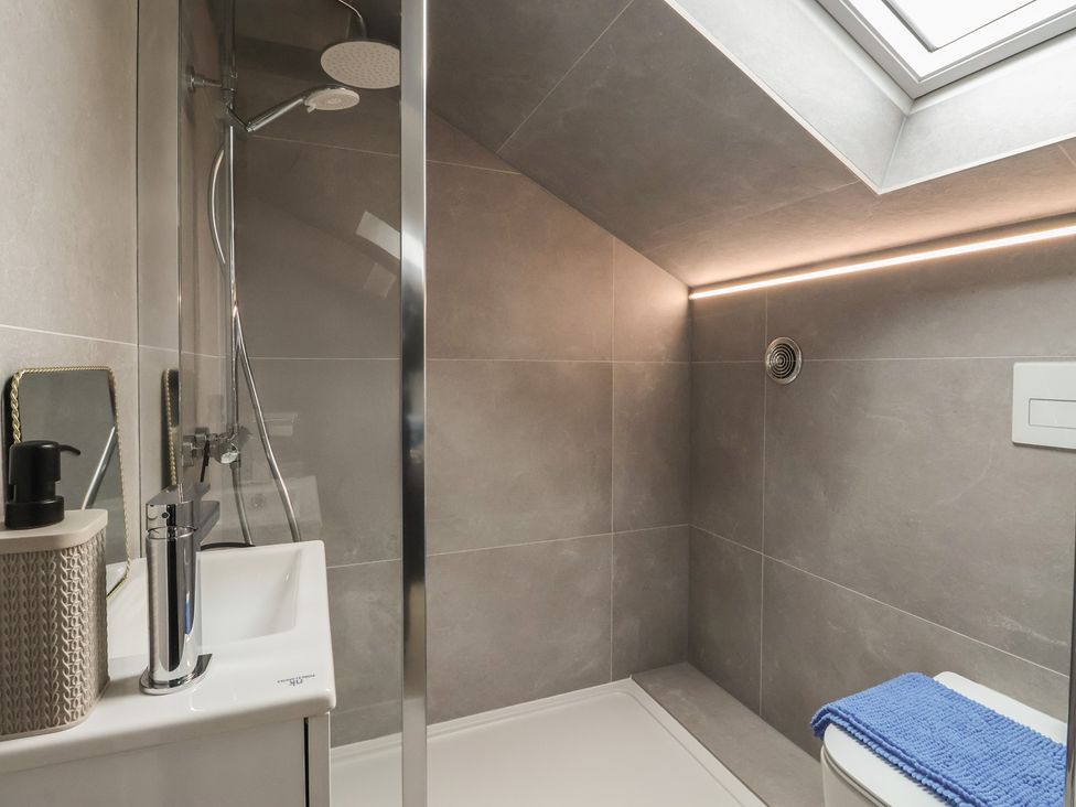 A bathroom with a shower and sink at Wood Cottage Winterburn