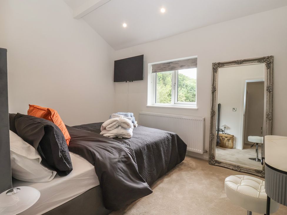 A bedroom with a bed and towels at Wood Cottage in Winterburn