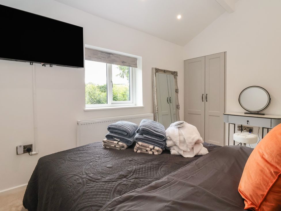 A bedroom with a bed and towels on it at Wood Cottage in Winterburn
