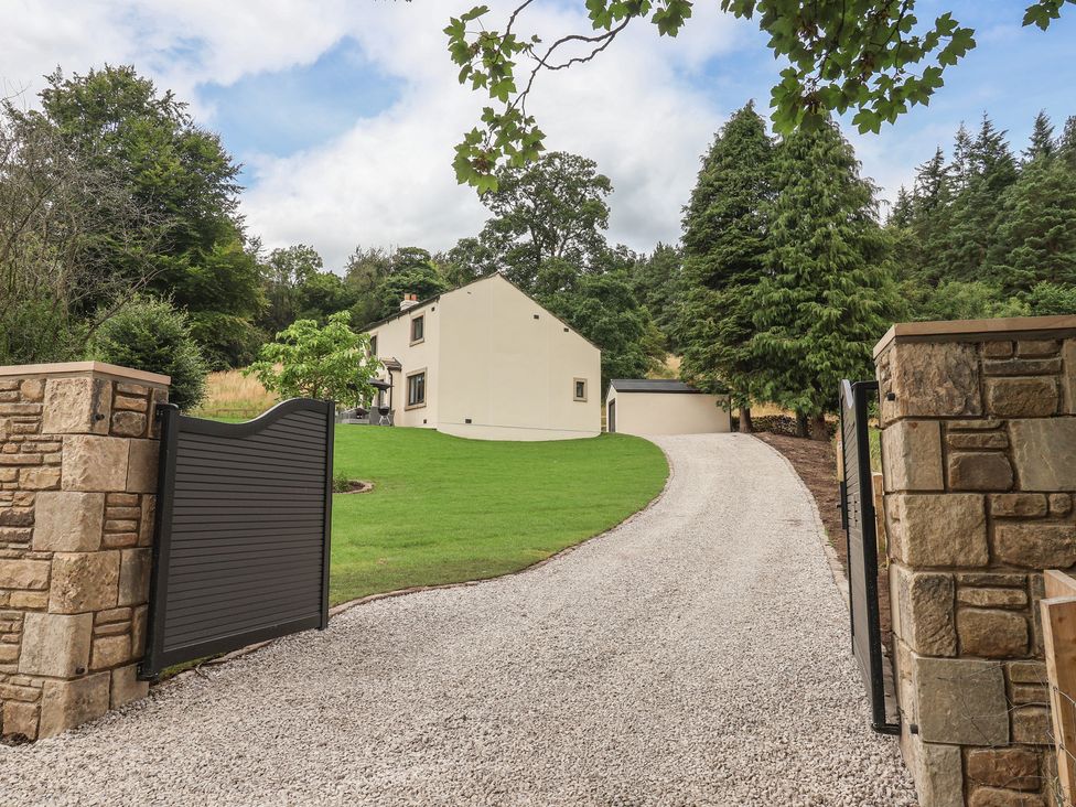 An outdoor area with a gravel driveway and house at Wood Cottage in Winterburn