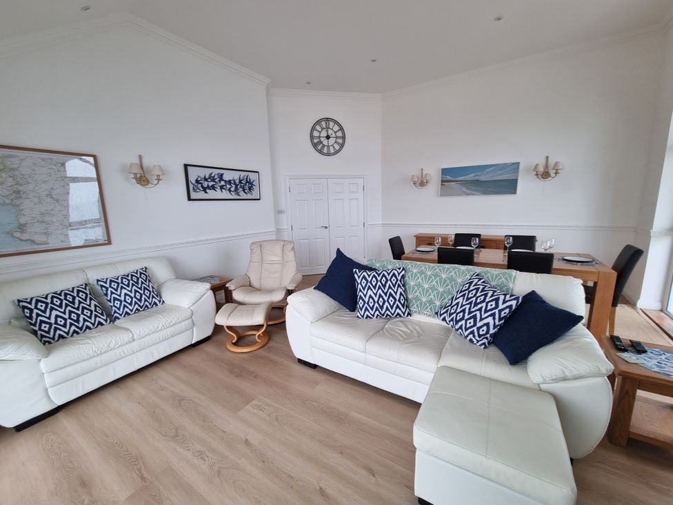 A living room with a sofa and dining area at Sea View Beach Apartment in Thurlestone
