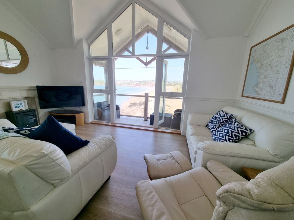 A living room with a sofa and television at Sea View Beach Apartment in Thurlestone