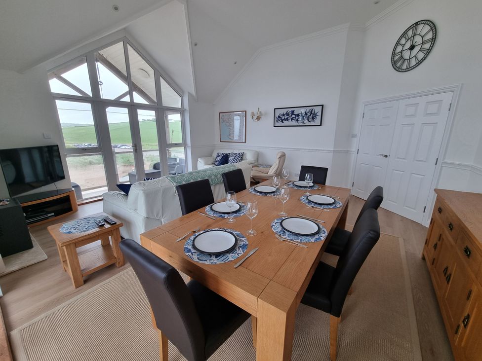 A dining area with a table and chairs at Sea View Beach Apartment in Thurlestone