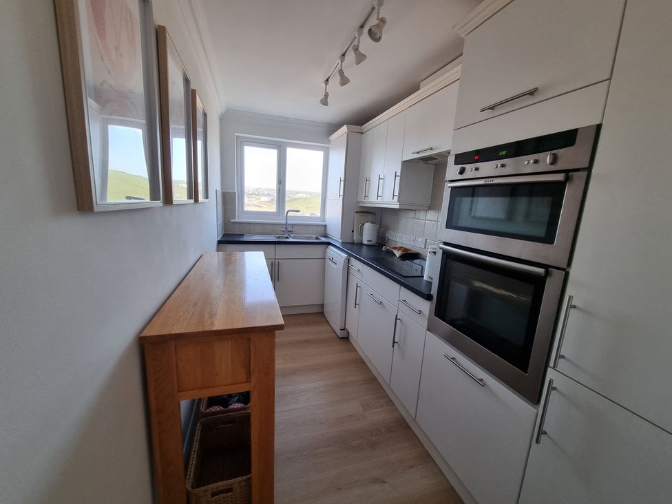 A kitchen with cabinets, sink, and oven in Sea View Beach Apartment Thurlestone