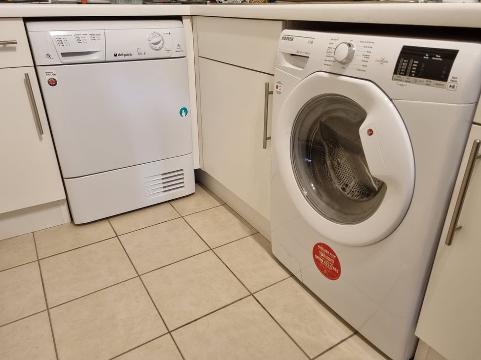A dishwasher and washing machine in a kitchen at Sea View Beach Apartment Thurlestone