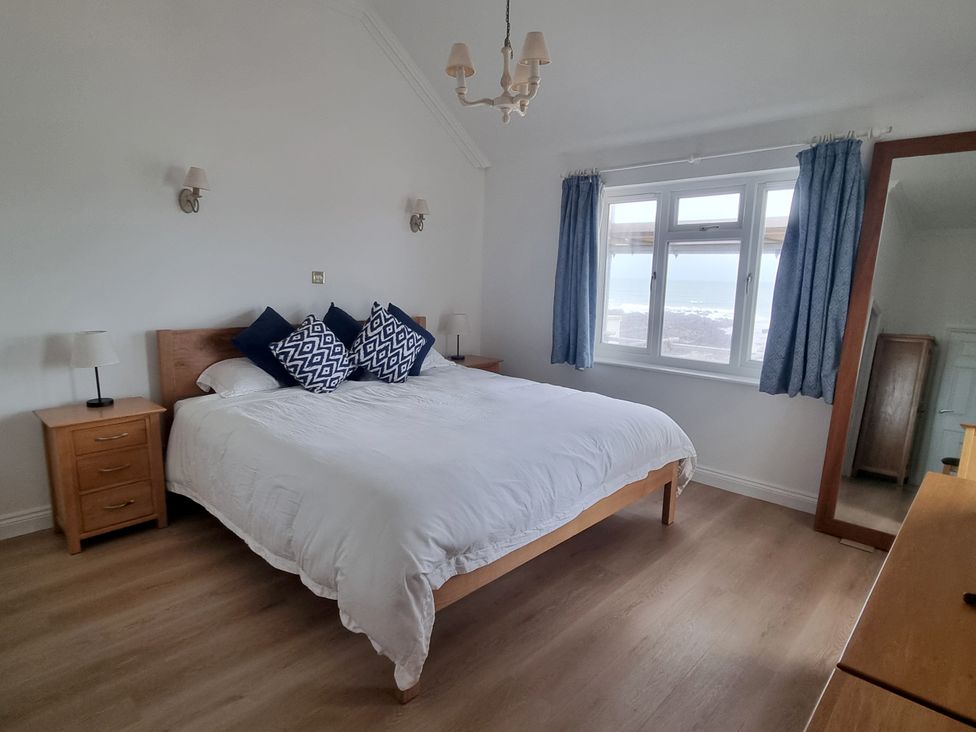 A bedroom with a bed and bedside lamps at Sea View Beach Apartment in Thurlestone