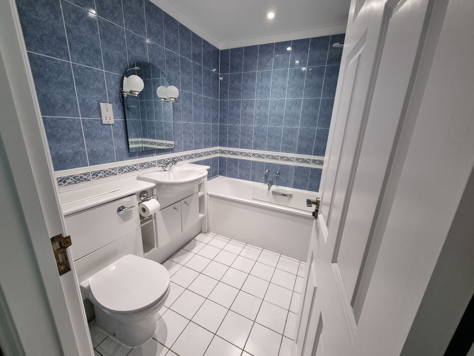 A bathroom with a sink, toilet and bathtub at Sea View Beach Apartment in Thurlestone