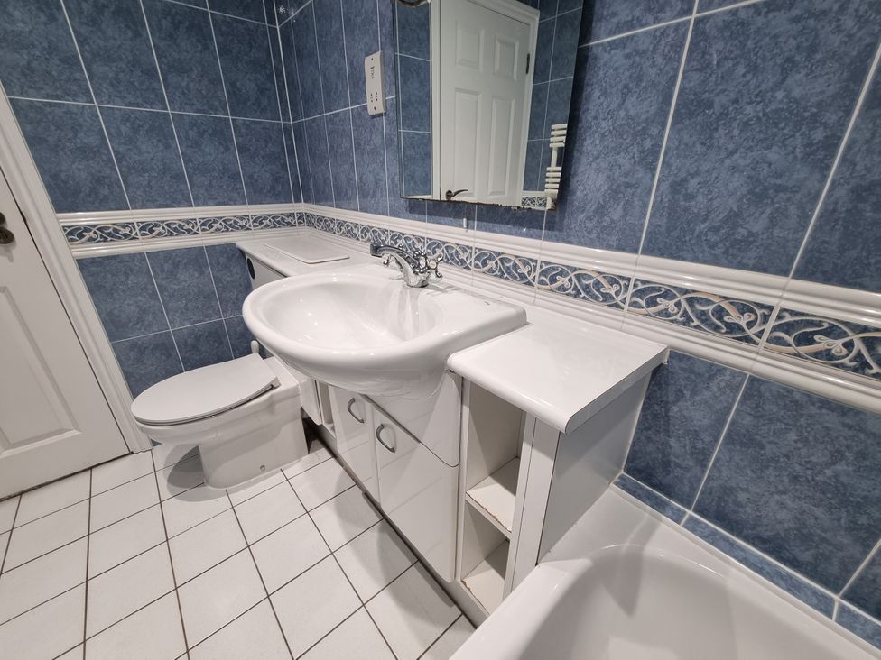 A bathroom with a sink and toilet at Sea View Beach Apartment Thurlestone