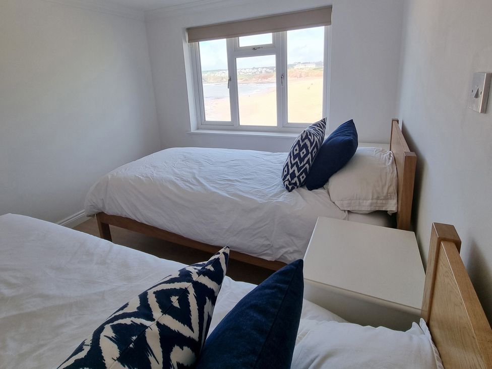 A bedroom with two beds and a window at Sea View Beach Apartment Thurlestone