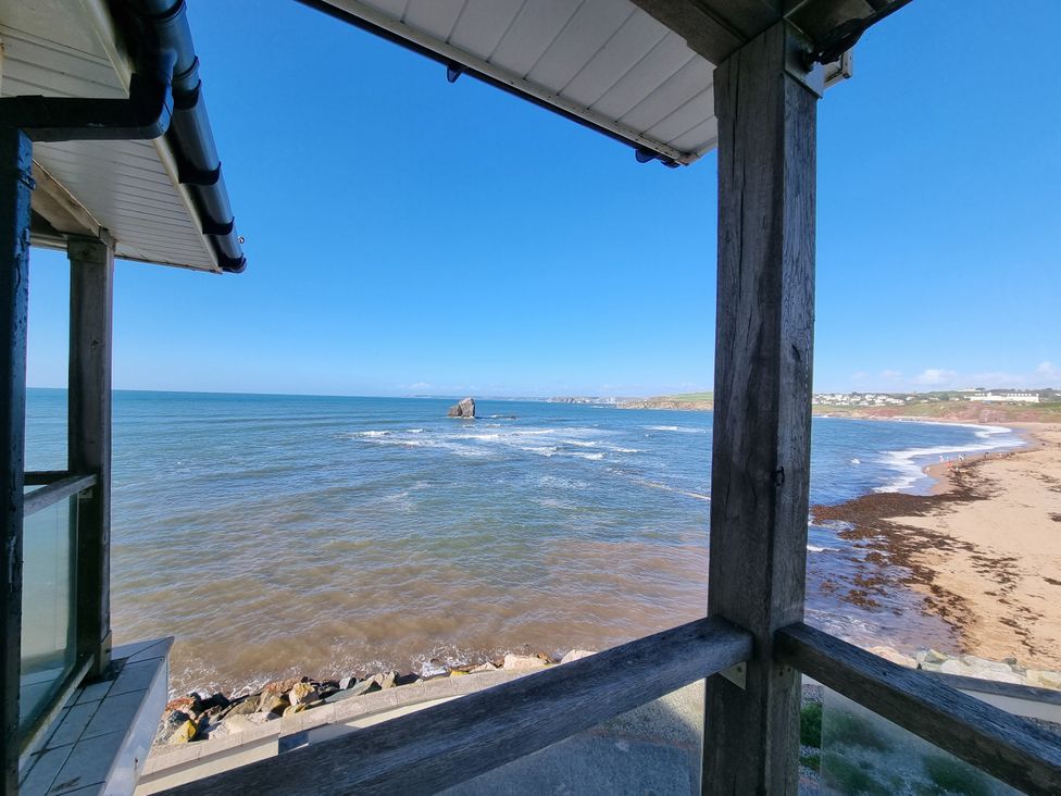 A view of the sea and beach from a wooden structure at Sea View Beach Apartment in Thurlestone