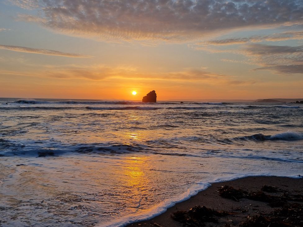 A beach scene with a sunset over the sea at Sea View Beach Apartment in Thurlestone